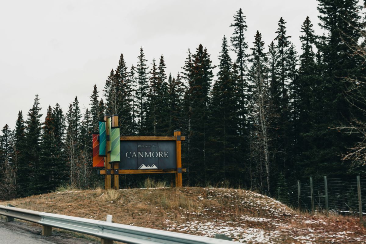 A sign reading Welcome to Canmore with trees in the background
