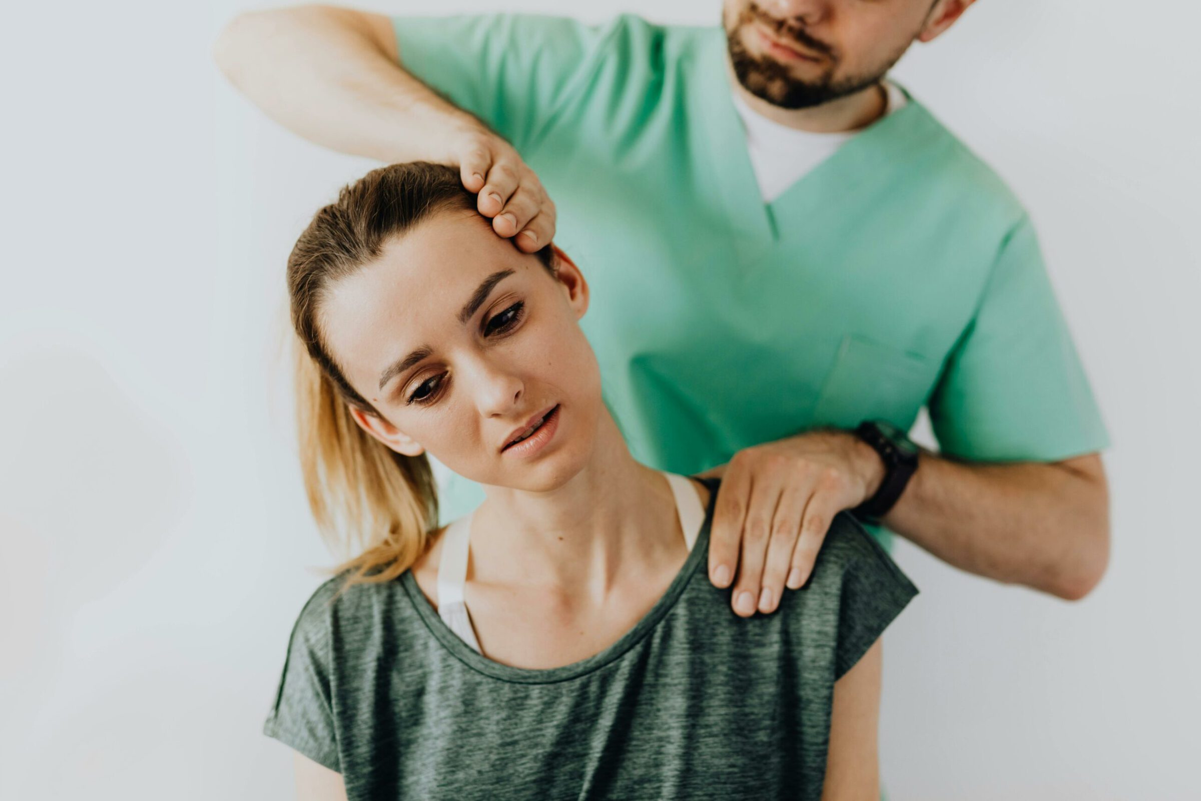A person having her neck examined by a doctor