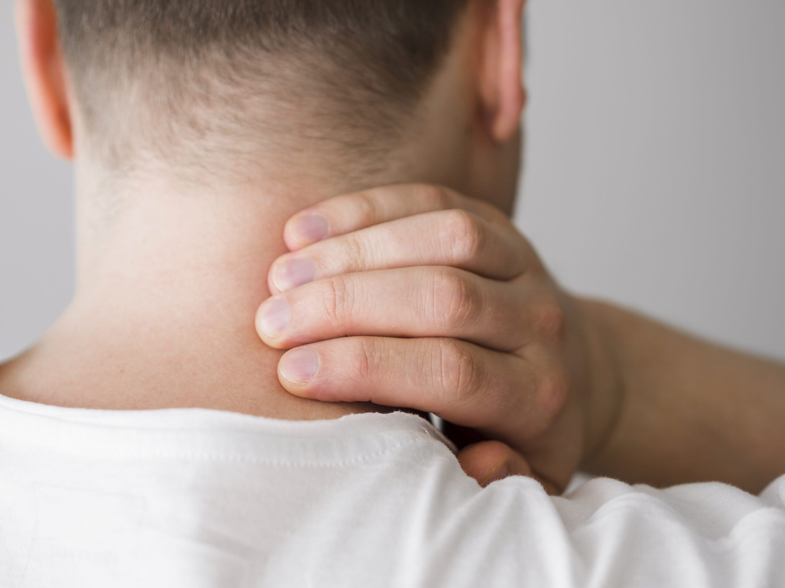 Person holding their neck in pain
