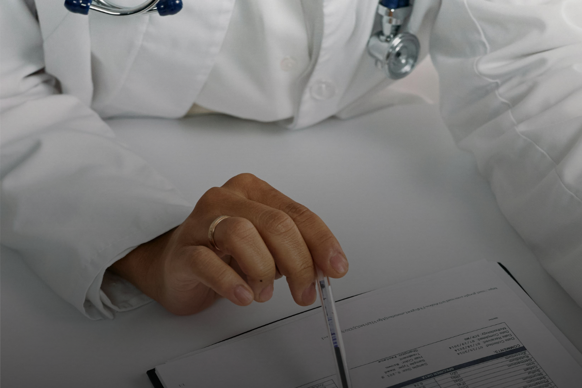 A doctor pointing at papers with a pen